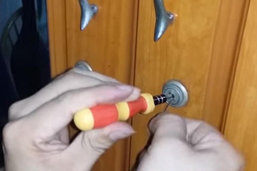 Thao tác mở khóa tủ bằng tua vít và dây kẽm dễ thực hiện
